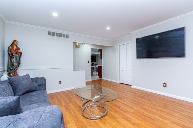 living room featuring visible vents, crown molding, baseboards, and wood finished floors