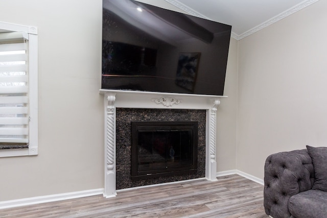 room details with a high end fireplace, crown molding, baseboards, and wood finished floors