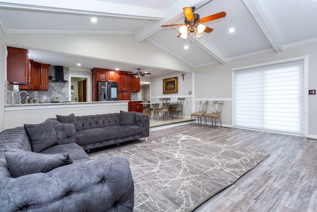 living area with ceiling fan, light wood-style flooring, recessed lighting, beam ceiling, and crown molding