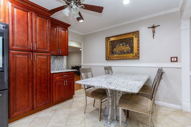 dining space featuring light tile patterned floors, ceiling fan, ornamental molding, and baseboards