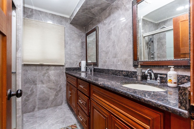 bathroom featuring double vanity, a stall shower, a sink, and tile walls