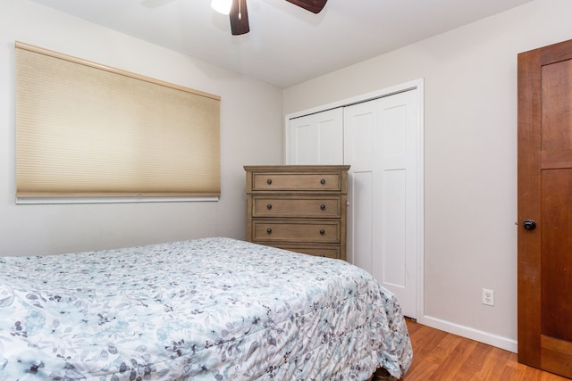 bedroom with ceiling fan, a closet, light wood-style flooring, and baseboards