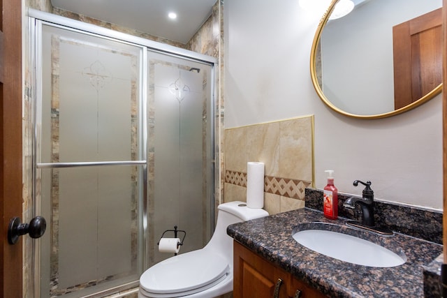 full bathroom featuring tile walls, a shower stall, vanity, and toilet