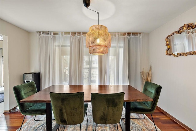 dining area with baseboards and wood finished floors