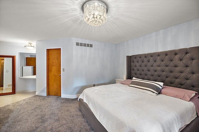 carpeted bedroom featuring an inviting chandelier, baseboards, and visible vents