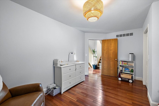 sitting room featuring hardwood / wood-style flooring, stairway, baseboards, and visible vents