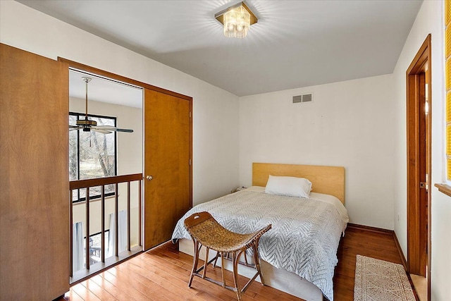 bedroom featuring visible vents, baseboards, light wood-style floors, and a closet