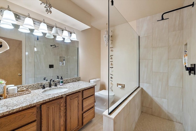 full bath featuring a tile shower, tile patterned floors, toilet, and vanity