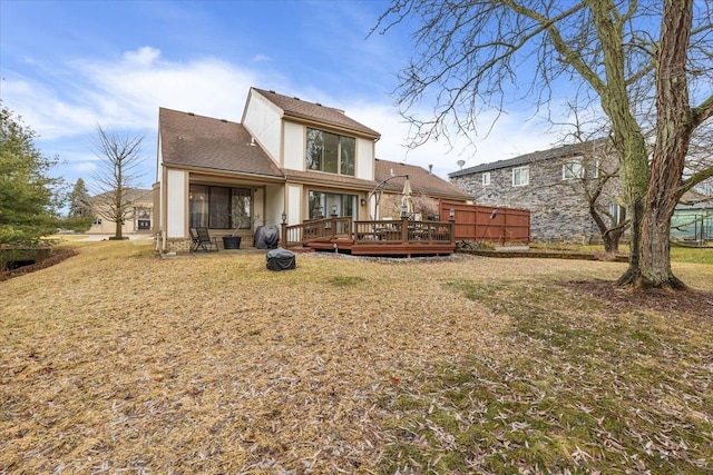 rear view of property featuring a yard and a wooden deck