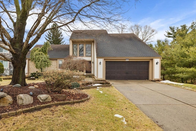 view of front facade featuring a garage, driveway, and a shingled roof