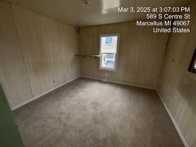 spare room with carpet, visible vents, and baseboards