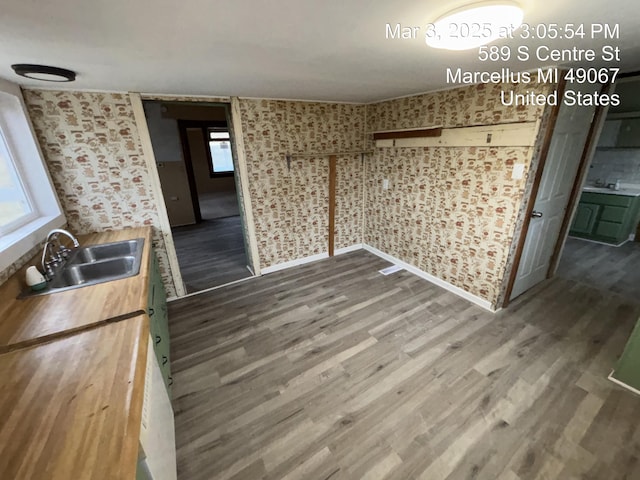 unfurnished dining area with a sink and wood finished floors