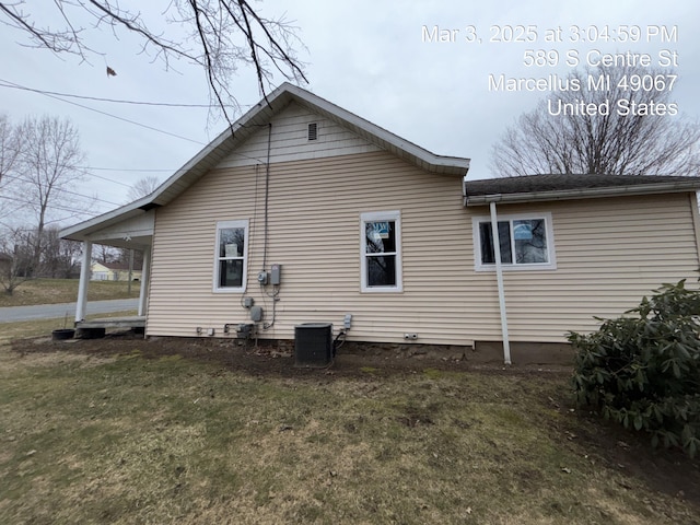 view of side of property featuring a yard and central AC unit