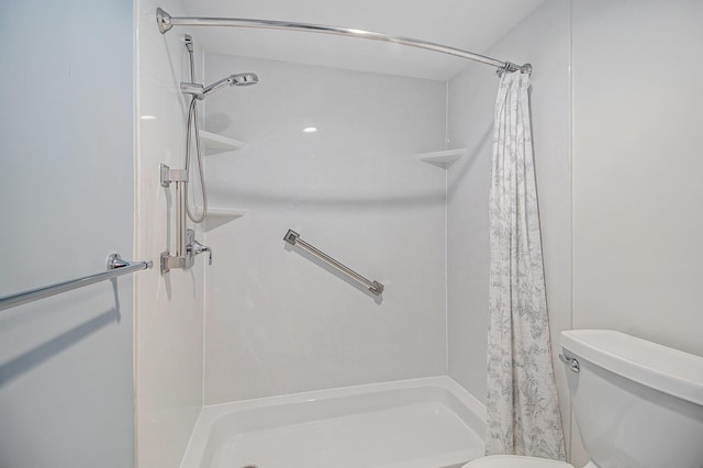 full bath featuring a shower stall and toilet