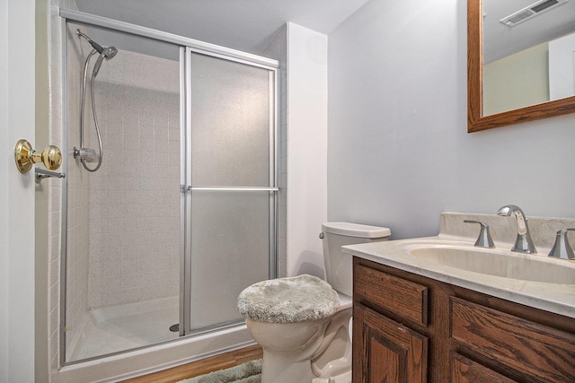 full bath featuring visible vents, toilet, a stall shower, vanity, and wood finished floors