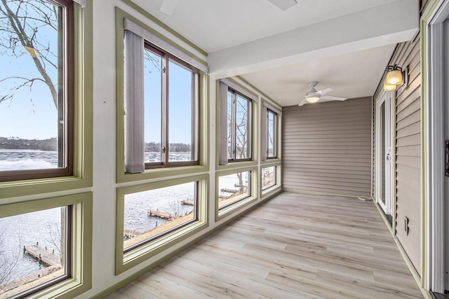 unfurnished sunroom featuring ceiling fan