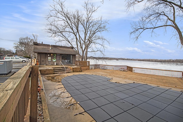 view of patio / terrace with central AC unit and a deck with water view