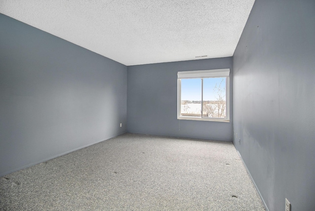 spare room featuring a textured ceiling and carpet floors