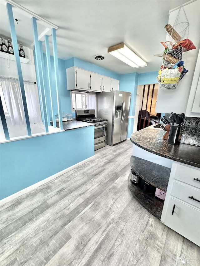 kitchen with stainless steel appliances, visible vents, white cabinetry, and light wood-style flooring