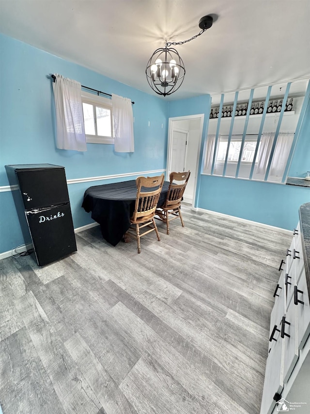 interior space with baseboards, a chandelier, and wood finished floors