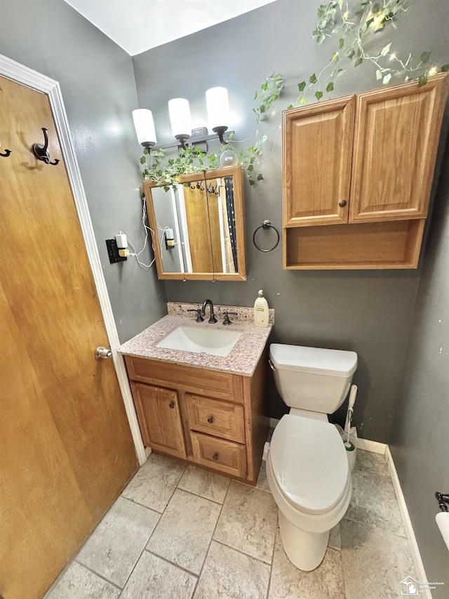 bathroom featuring vanity, toilet, and baseboards