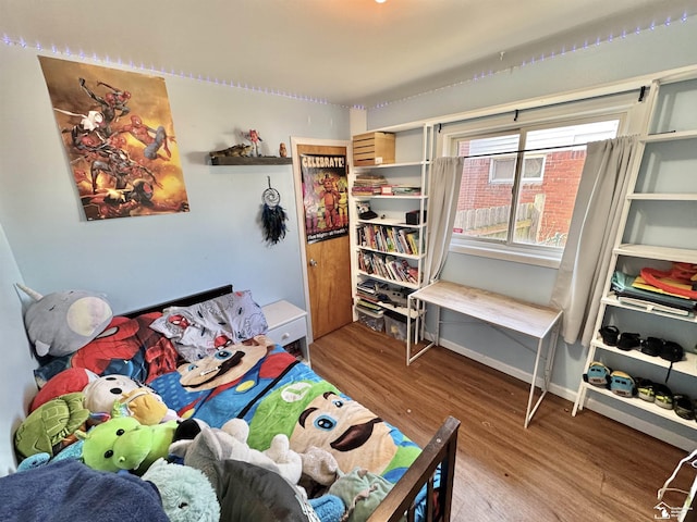 bedroom featuring wood finished floors and baseboards