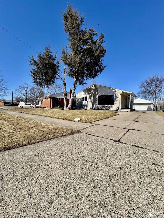 view of front of home with concrete driveway and a front lawn