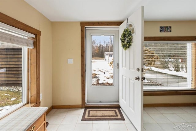 doorway to outside featuring light tile patterned flooring and baseboards