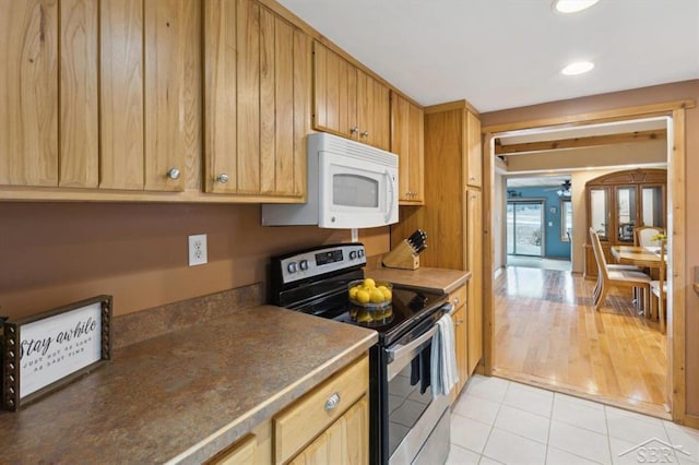 kitchen with french doors, light tile patterned floors, dark countertops, white microwave, and stainless steel range with electric cooktop