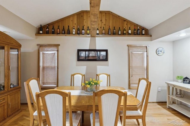 dining room with lofted ceiling and light wood-type flooring