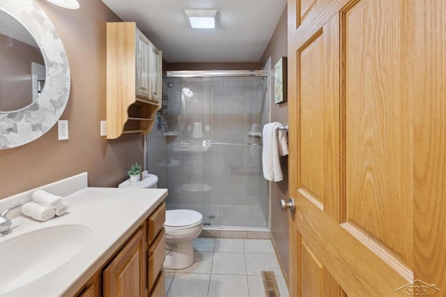 full bath featuring tile patterned flooring, a shower stall, toilet, and vanity