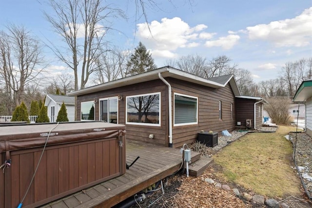 exterior space featuring a deck, central AC unit, and a hot tub