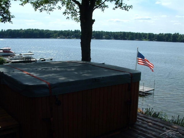 exterior space featuring a water view and a hot tub