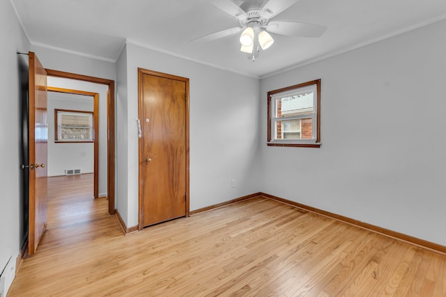 unfurnished bedroom with light wood-style floors, crown molding, visible vents, and a closet