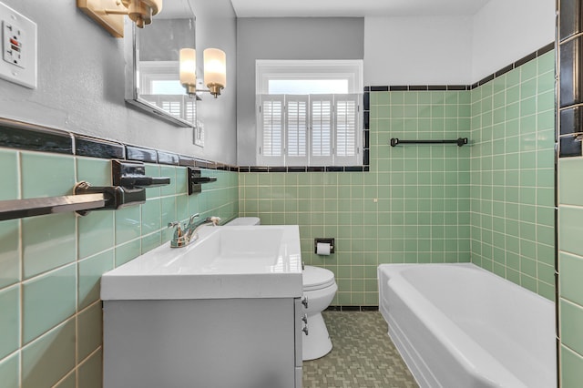 bathroom featuring wainscoting, vanity, toilet, and tile walls