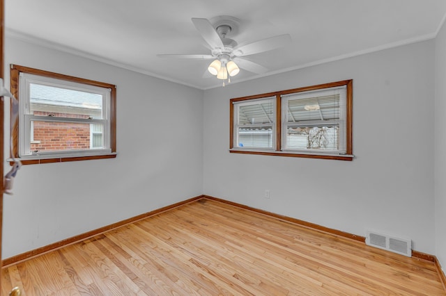 unfurnished room featuring baseboards, visible vents, ceiling fan, and wood finished floors