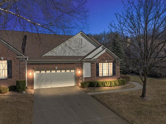 view of front facade with brick siding, an attached garage, and driveway