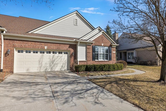 view of front facade featuring brick siding, driveway, a front yard, and a garage