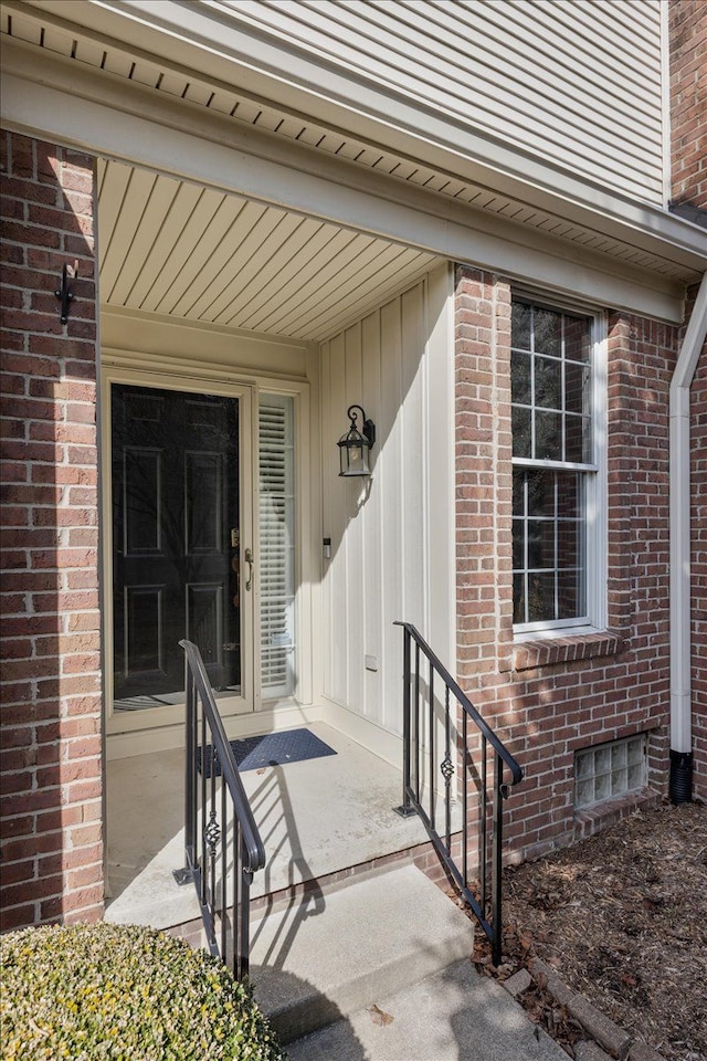 doorway to property featuring brick siding