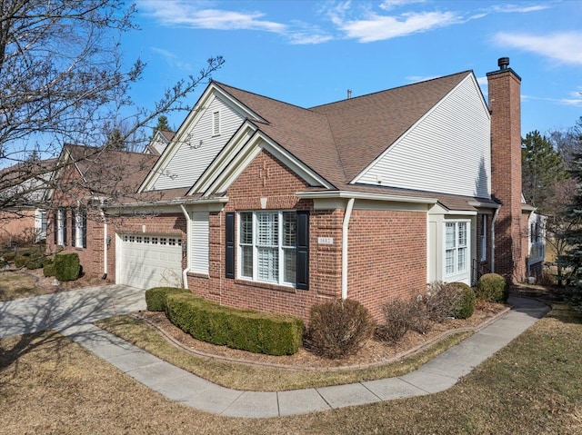 view of home's exterior with roof with shingles, driveway, an attached garage, a chimney, and brick siding