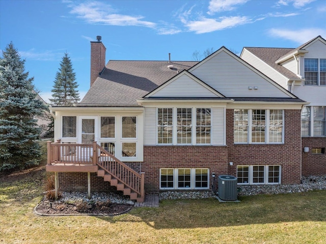 rear view of house with central AC, a yard, stairway, a sunroom, and a chimney