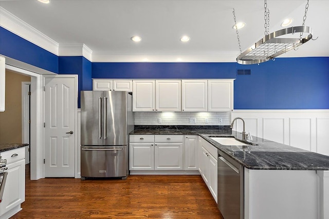 kitchen featuring visible vents, crown molding, appliances with stainless steel finishes, dark wood-style floors, and a sink