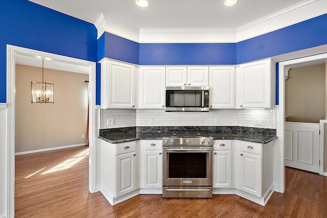 kitchen with crown molding, a chandelier, dark wood finished floors, white cabinets, and stainless steel appliances