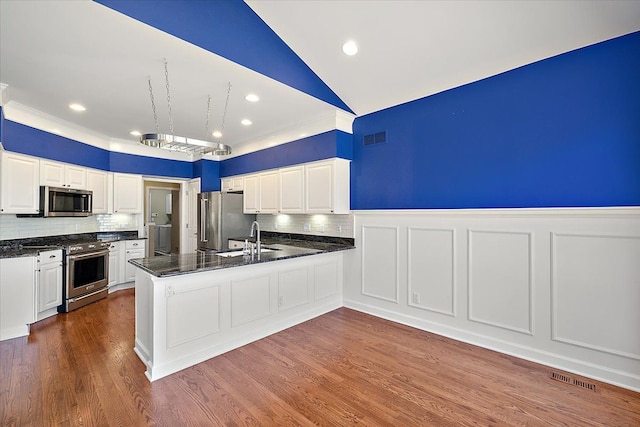 kitchen featuring dark wood-style floors, visible vents, a sink, appliances with stainless steel finishes, and white cabinetry