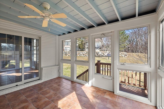 sunroom featuring lofted ceiling with beams, a healthy amount of sunlight, and ceiling fan