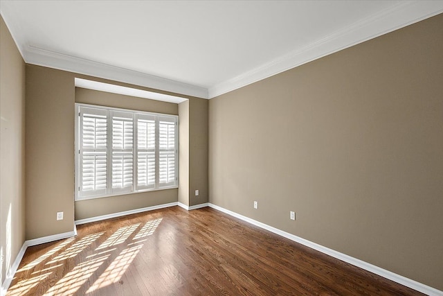 spare room featuring baseboards, dark wood-style floors, and crown molding