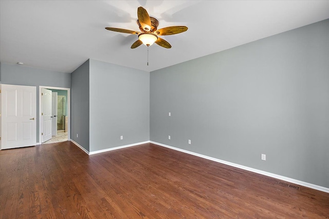 empty room with visible vents, baseboards, dark wood-style flooring, and a ceiling fan