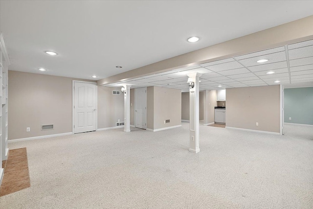 finished basement featuring light carpet, visible vents, and baseboards