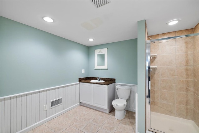 bathroom featuring tile patterned flooring, visible vents, wainscoting, and a stall shower