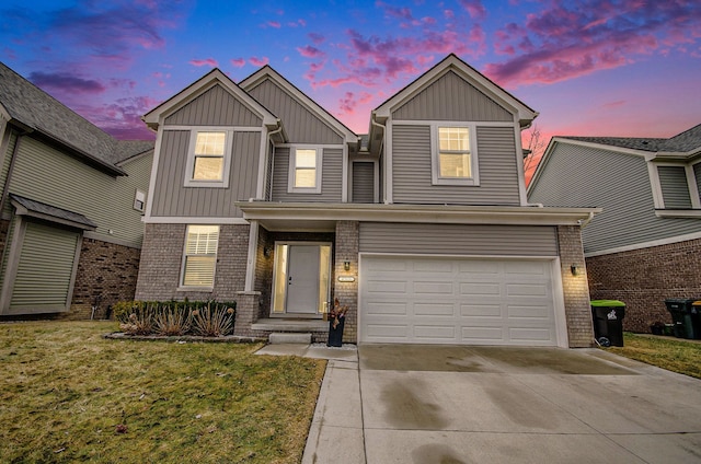 traditional home with brick siding, a yard, board and batten siding, a garage, and driveway